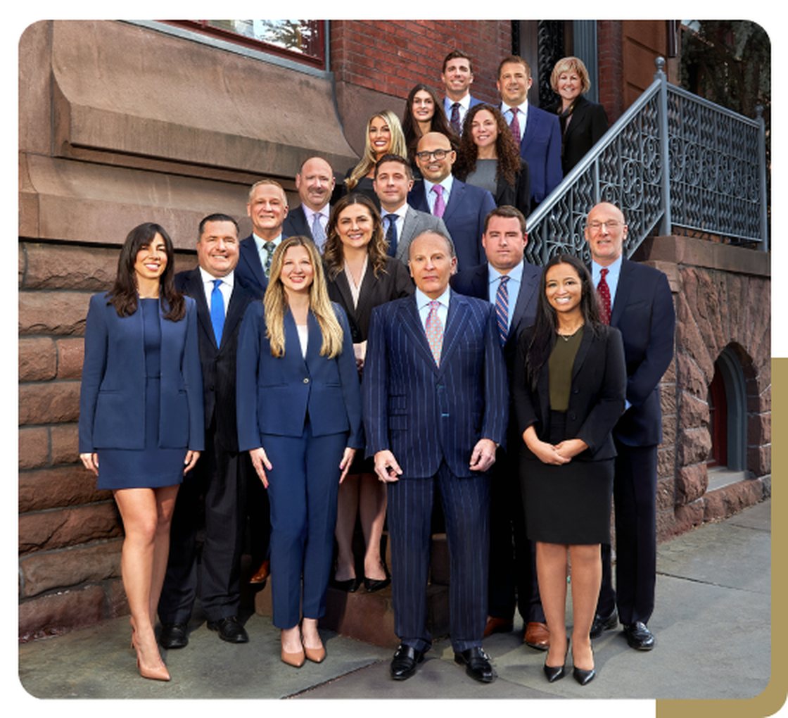 The attorneys and staff of Messa Law photographed together on the steps outside the firm offices